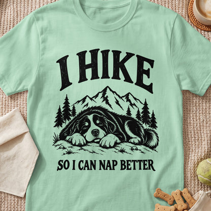 Mint t-shirt with black graphic of sleeping dog, mountains, trees, and text "I HIKE SO I CAN NAP BETTER".