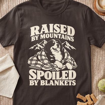 T-shirt with text "RAISED BY MOUNTAINS SPOILED BY BLANKETS" and a dog.
