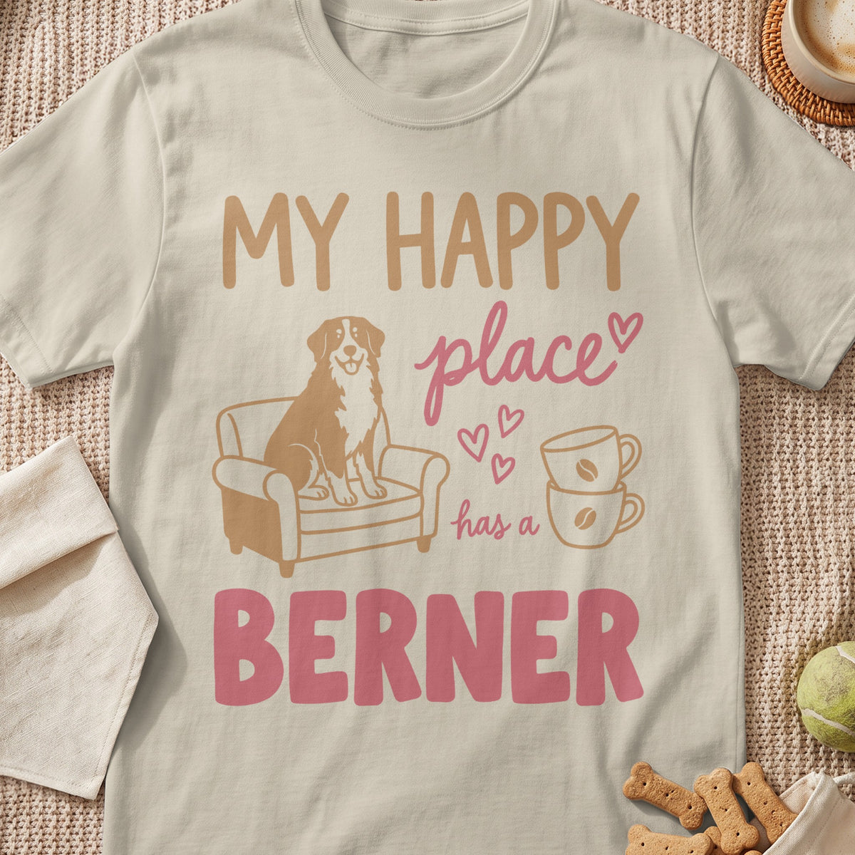 T-shirt with text "MY HAPPY place has a BERNER", dog on armchair, coffee cups.