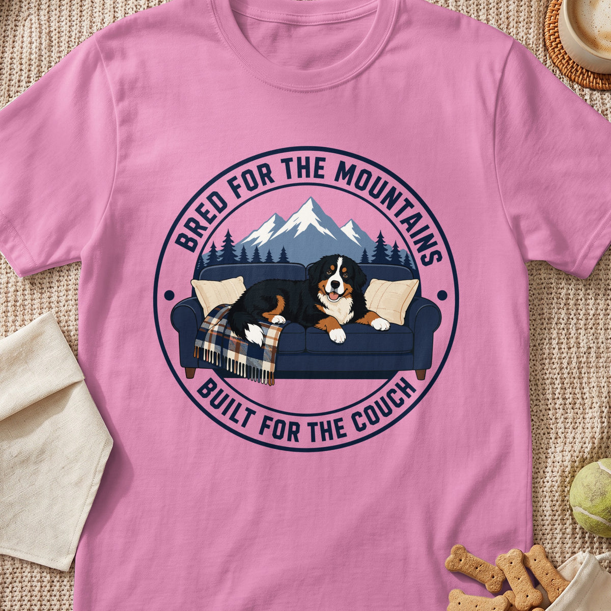 Bernese Mountain Dog on couch with mountains and text: Bred for the mountains, built for the couch.