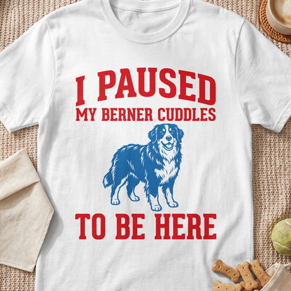 White t-shirt with red text that reads "I PAUSED MY BERNER CUDDLES TO BE HERE" above a dog.