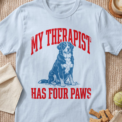 Light blue t-shirt with red text "MY THERAPIST HAS FOUR PAWS" and a dog illustration.
