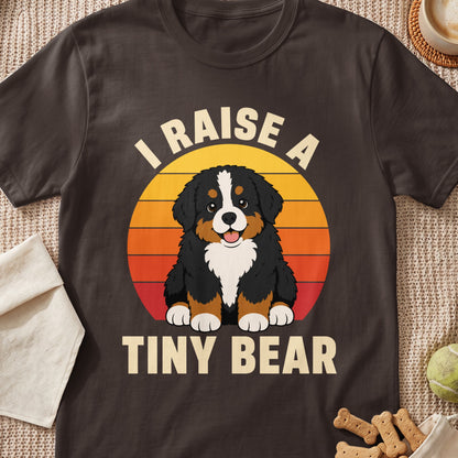 Bernese Mountain Dog with text "I Raise A Tiny Bear" in front of sunset graphic.