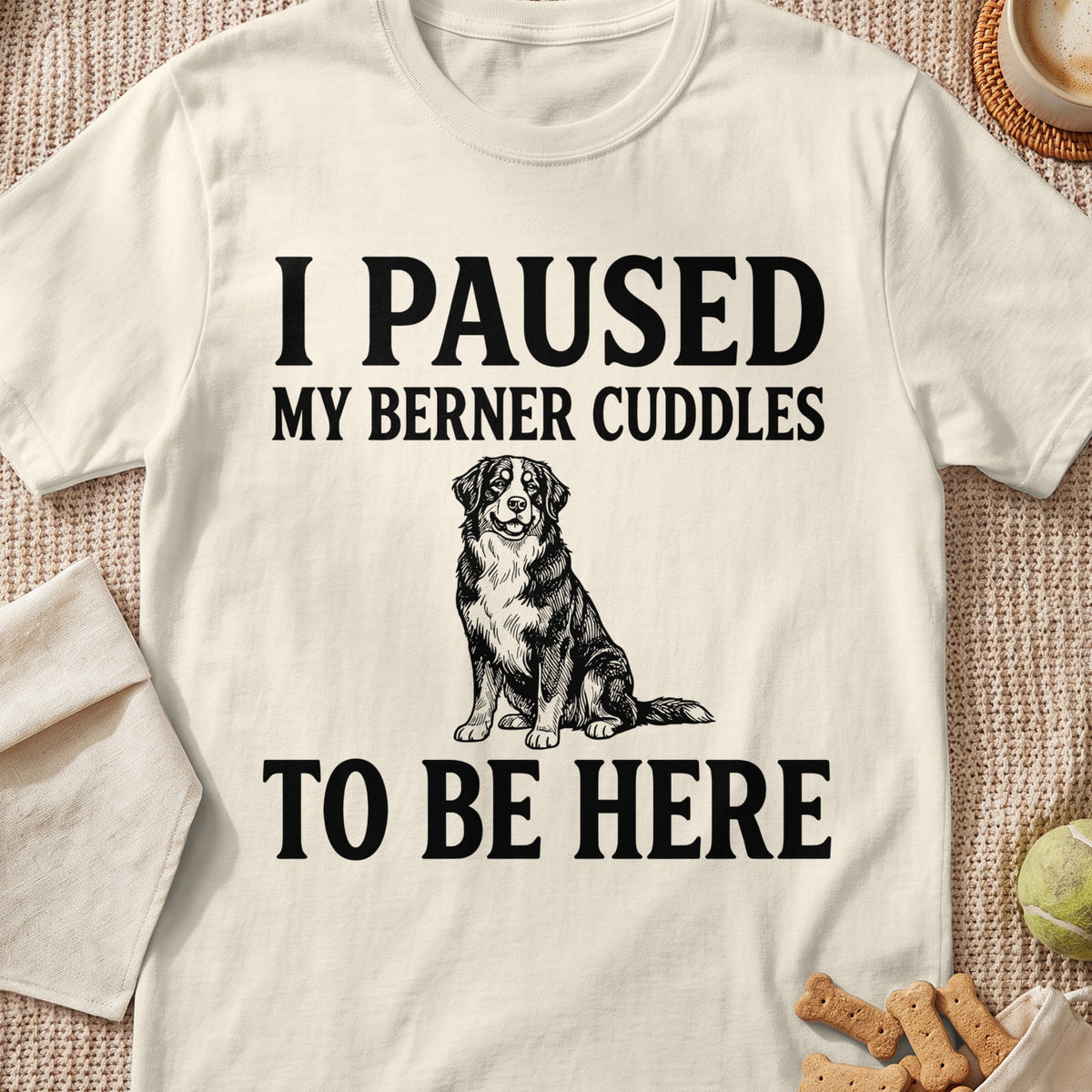 Cream t-shirt with black text "I PAUSED MY BERNER CUDDLES TO BE HERE" and dog illustration.