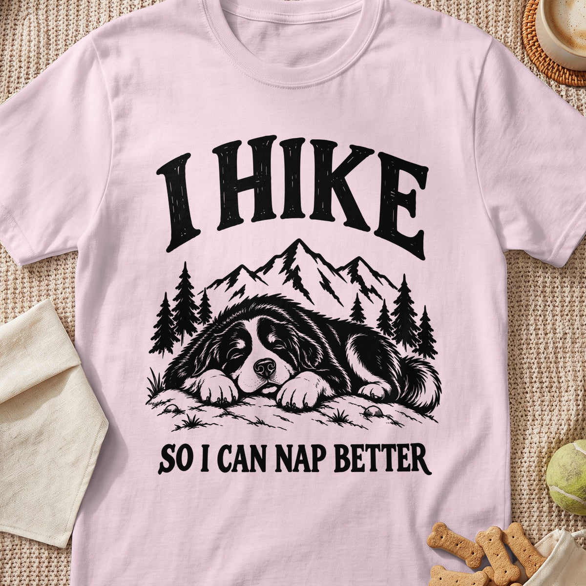 Pink t-shirt with black text and illustration of a dog napping with mountains and trees.