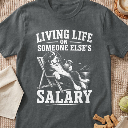 Bernese Mountain Dog relaxing in a deck chair with drink and text "LIVING LIFE ON SOMEONE ELSE'S SALARY".