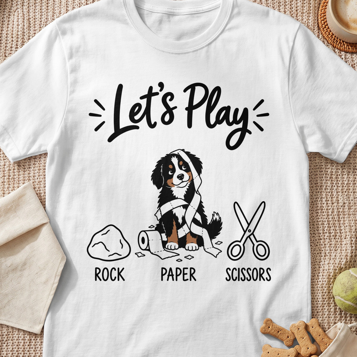 White t-shirt graphic with dog, toilet paper, rock, and scissors, text "Let's Play".