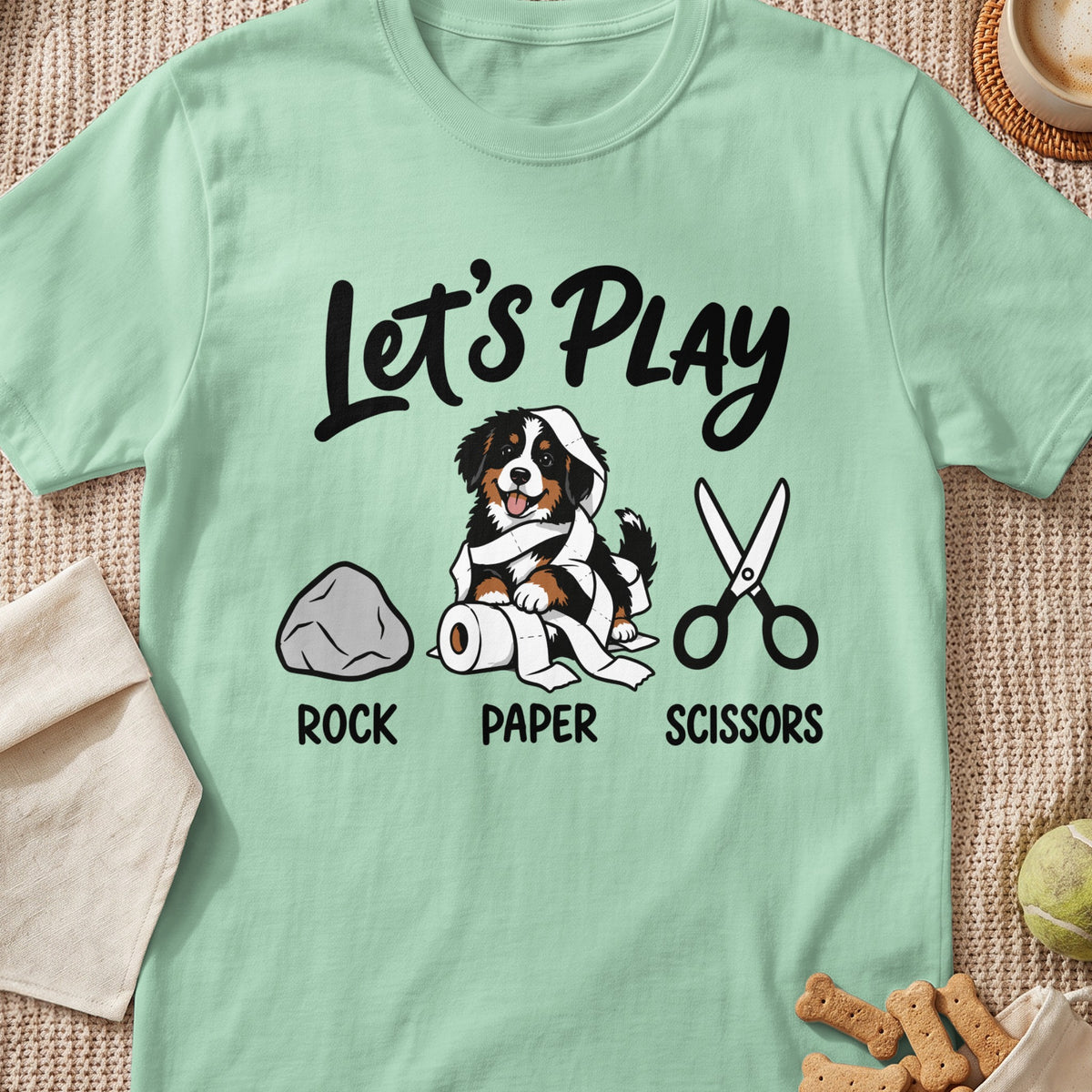 Bernese Mountain Dog wrapped in toilet paper with rock, paper, scissors.