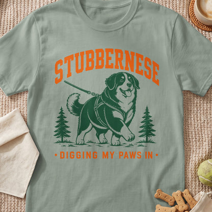 Green t-shirt with a dog illustration and text "STUBBERNESE DIGGING MY PAWS IN".