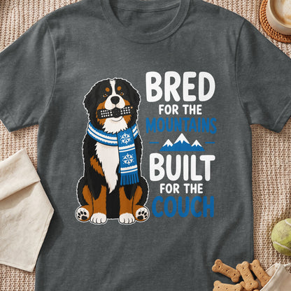 Bernese Mountain Dog wearing scarf holding remote, text "BRED FOR THE MOUNTAINS BUILT FOR THE COUCH".