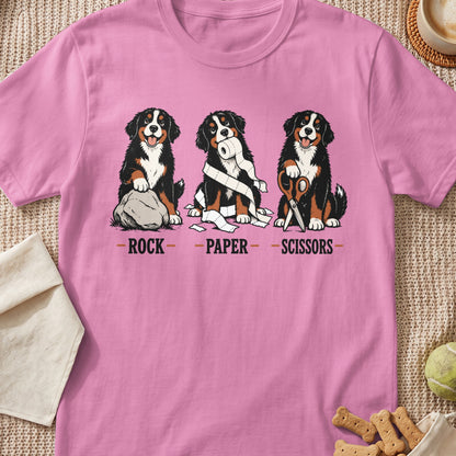 Bernese Mountain Dogs play rock, paper, scissors with a rock, toilet paper, and scissors.