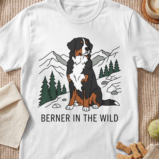 Bernese Mountain Dog sitting in a mountain landscape with "BERNER IN THE WILD" text.