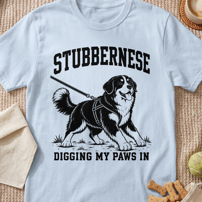Light blue t-shirt with black graphic of a Bernese Mountain Dog on a leash, text "STUBBERNESE DIGGING MY PAWS IN".