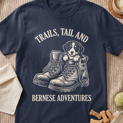 Bernese puppy in boots with "Trails, Tail and Bernese Adventures" text.