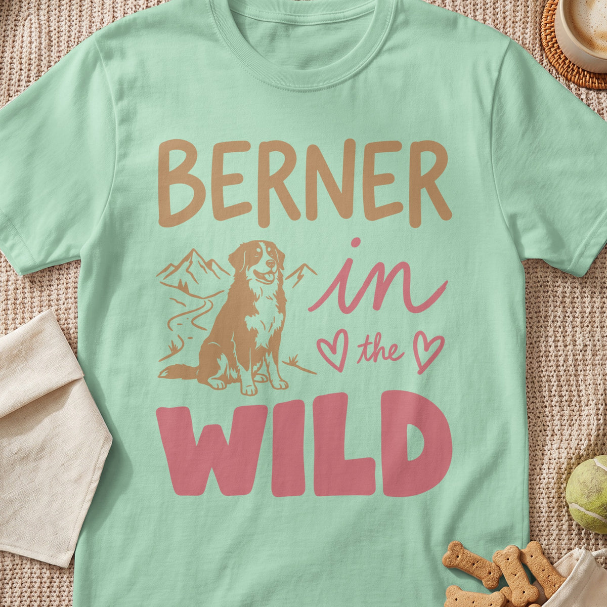 Berner in the Wild text with a dog graphic and mountains on a mint t-shirt.