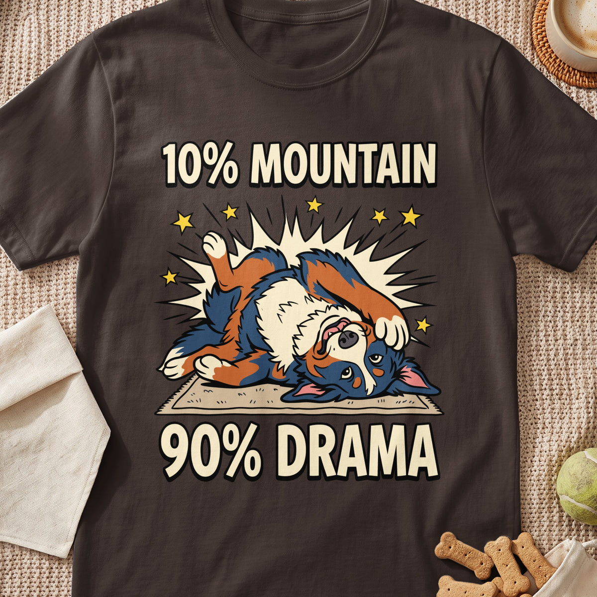 A brown t-shirt featuring a cartoon Bernese Mountain Dog lying dramatically on its back with the text 10% MOUNTAIN 90% DRAMA.