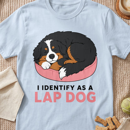 Light blue t-shirt with cartoon of Bernese Mountain Dog sleeping on pink bed with text I IDENTIFY AS A LAP DOG.
