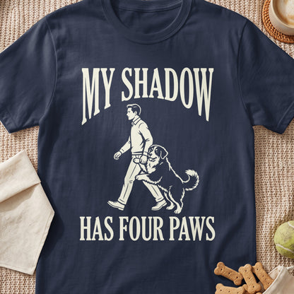 T-shirt with "MY SHADOW HAS FOUR PAWS" text and a man walking a dog design.