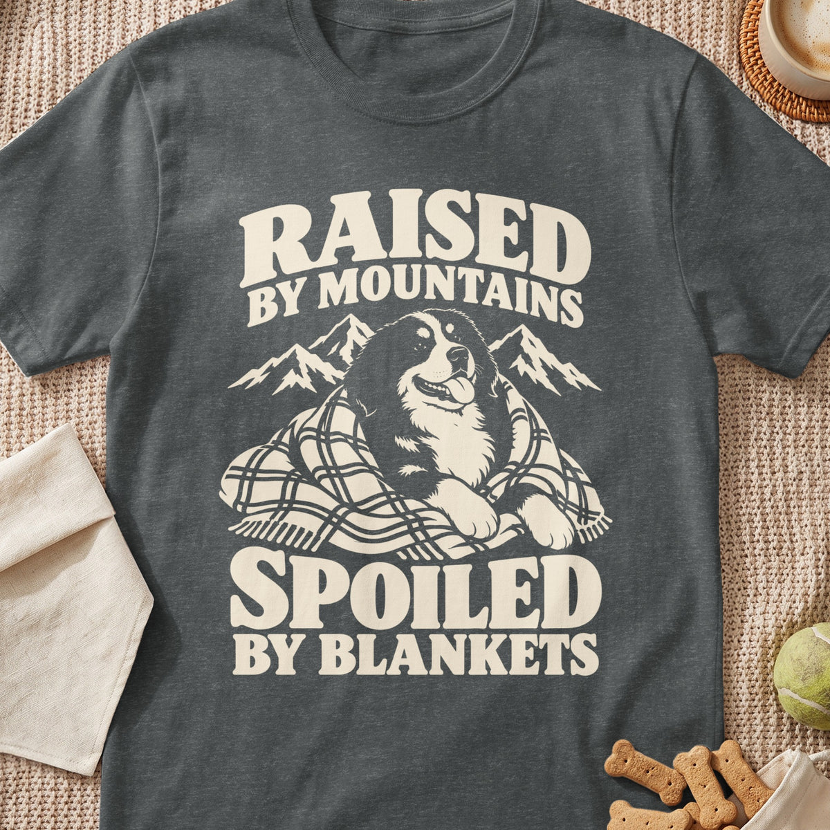 Bernese Mountain Dog wrapped in blanket with "Raised by Mountains Spoiled by Blankets" text.