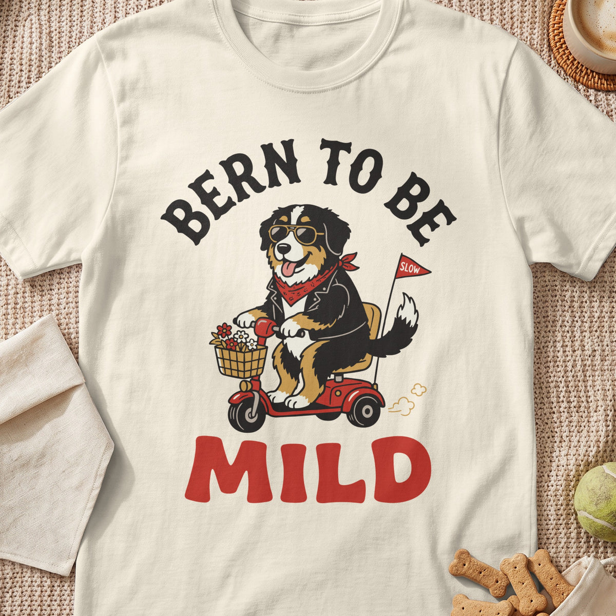 Bernese Mountain Dog wearing sunglasses rides a scooter with text "Bern to Be Mild".