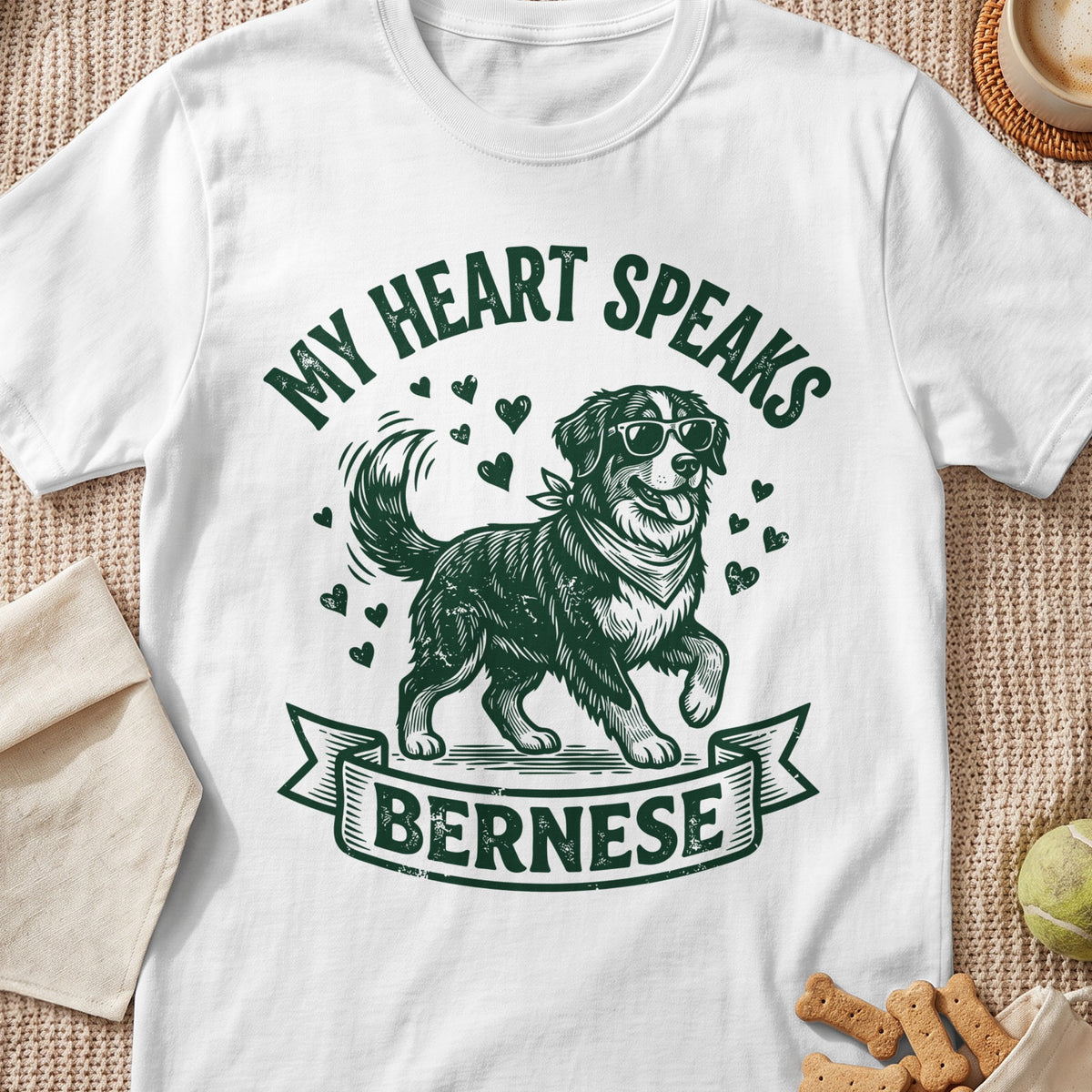 White t-shirt with green graphic of Bernese dog wearing sunglasses and text "My Heart Speaks Bernese".