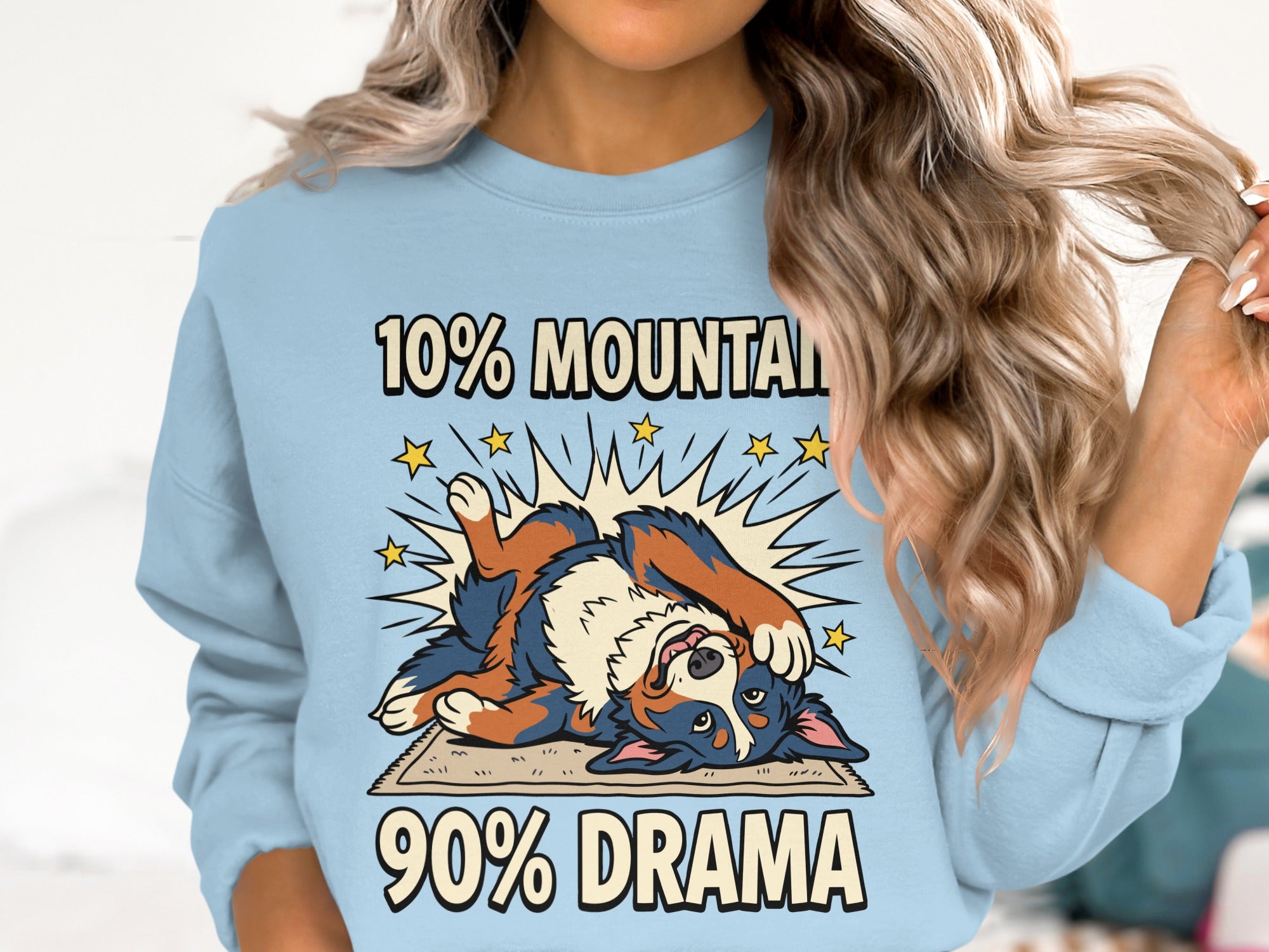 Light blue sweatshirt with "10% MOUNTAIN 90% DRAMA" text and a cartoon dog.