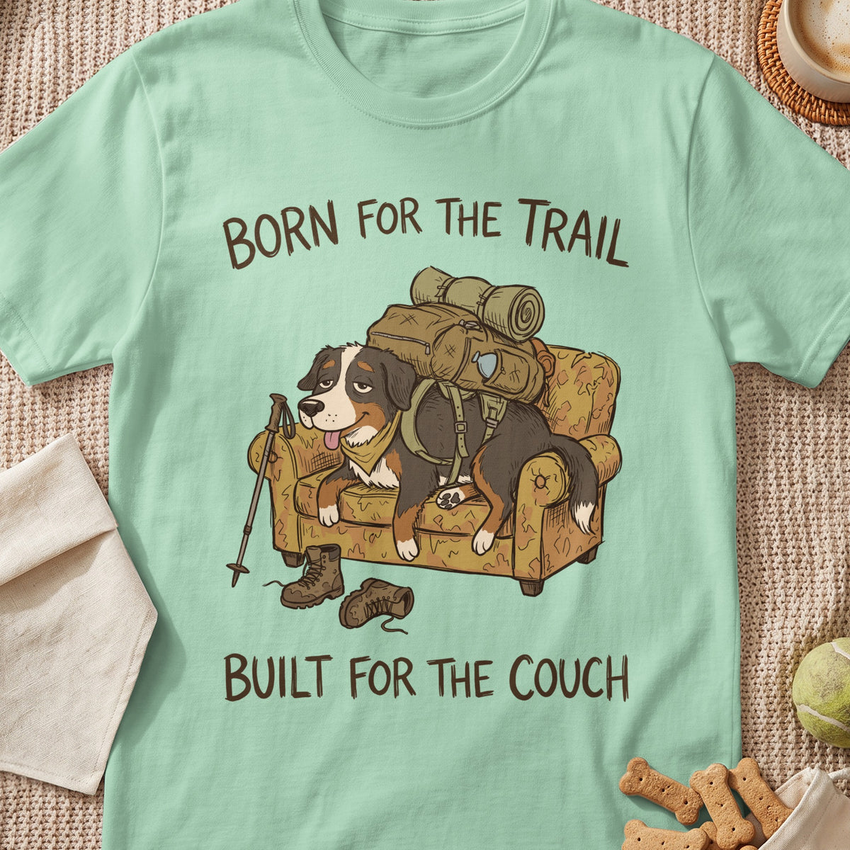 Bernese Mountain Dog wearing backpack on couch, text "Born for the Trail, Built for the Couch."