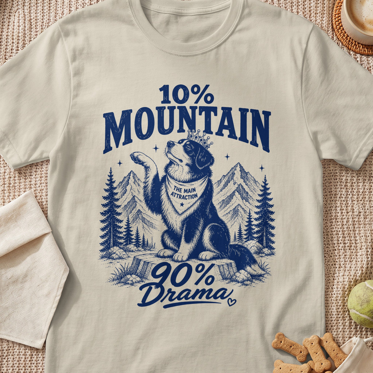 T-shirt graphic with a dog wearing a crown and bandana, mountains, and text.