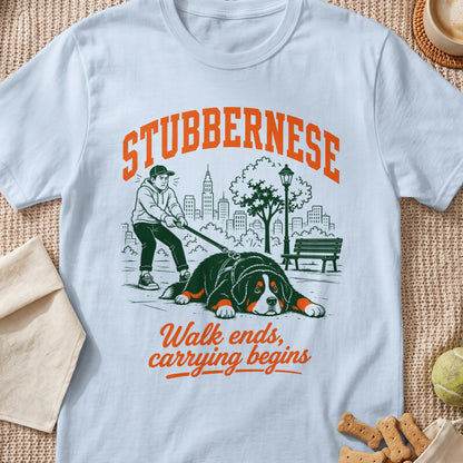 White t-shirt with "STUBBERNESE" and a drawing of a boy struggling to walk a Bernese Mountain Dog.