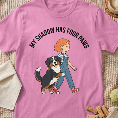 Pink t-shirt with "MY SHADOW HAS FOUR PAWS" and illustration of a girl and a dog.