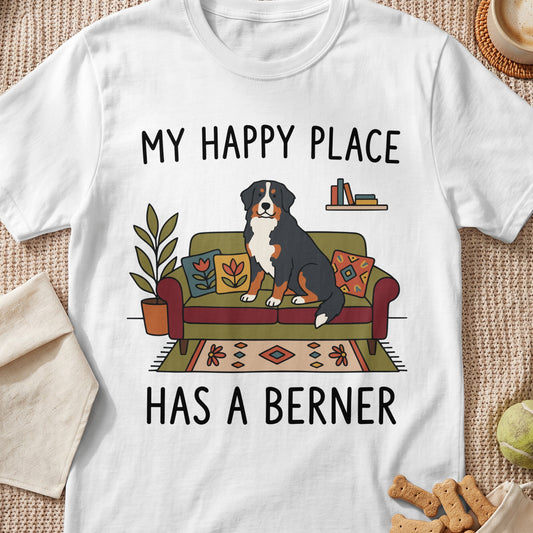 White t-shirt with illustration of Bernese Mountain Dog on couch and text "My Happy Place Has A Berner".