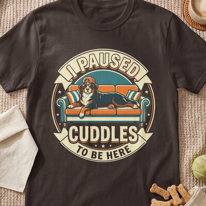 Bernese Mountain Dog wearing sunglasses and hat on couch with text "I Paused Cuddles To Be Here".