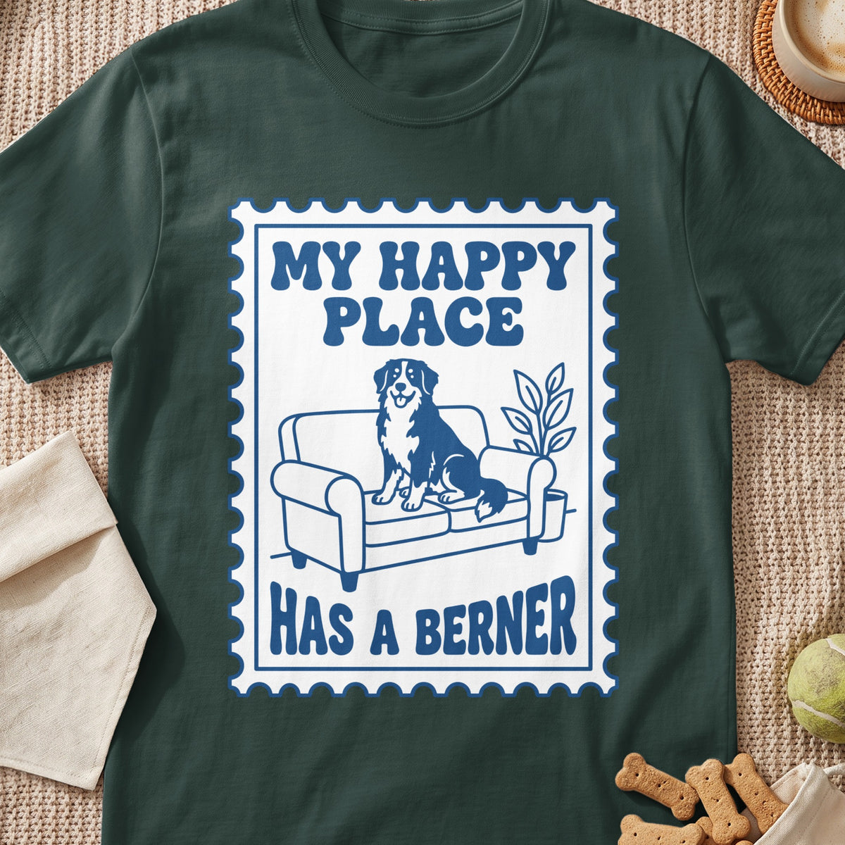 Dark green t-shirt with a stamp design featuring a Bernese Mountain Dog on a couch and text.