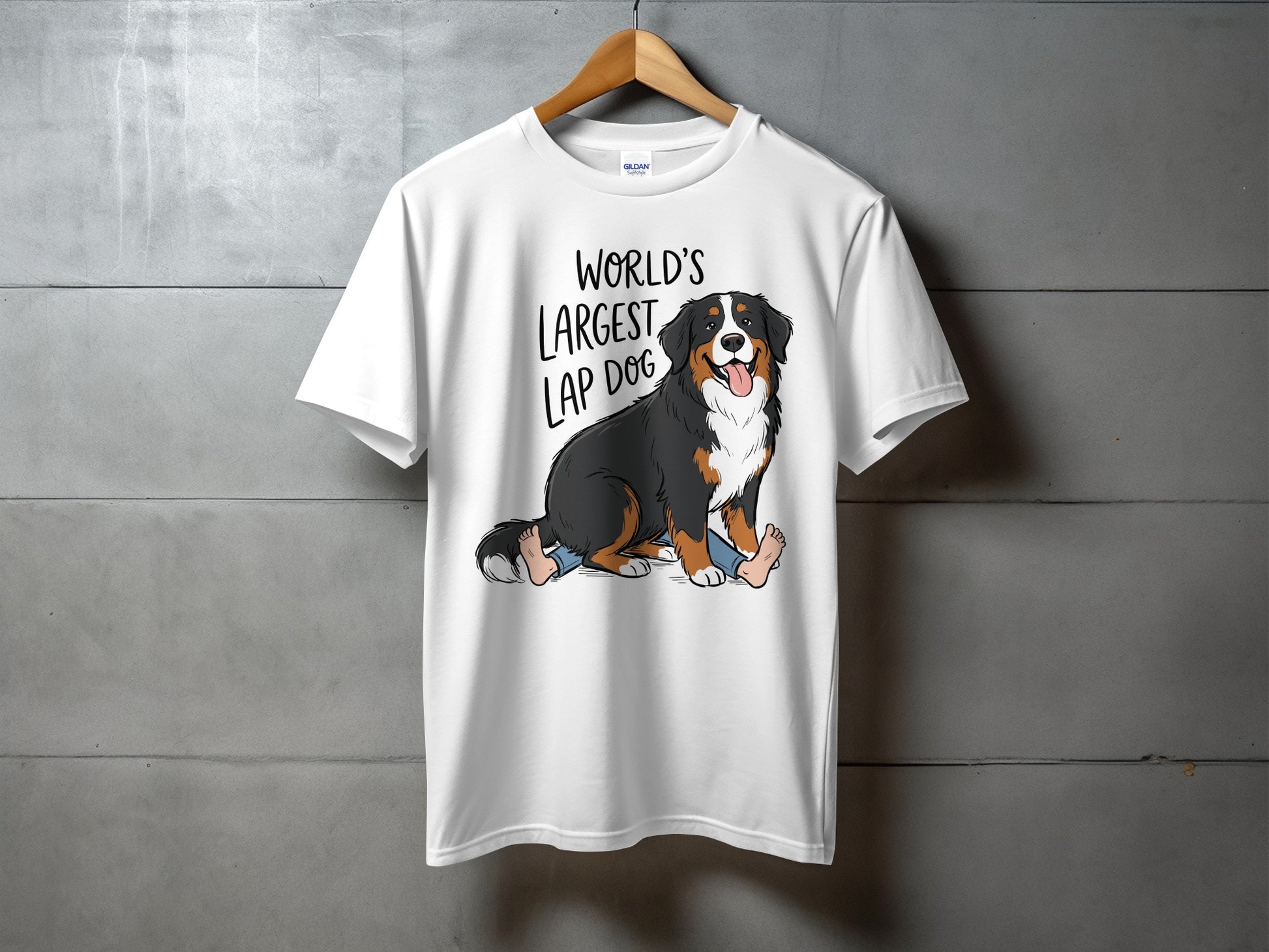 White t-shirt with cartoon of Bernese Mountain Dog sitting on legs with text "WORLD'S LARGEST LAP DOG".