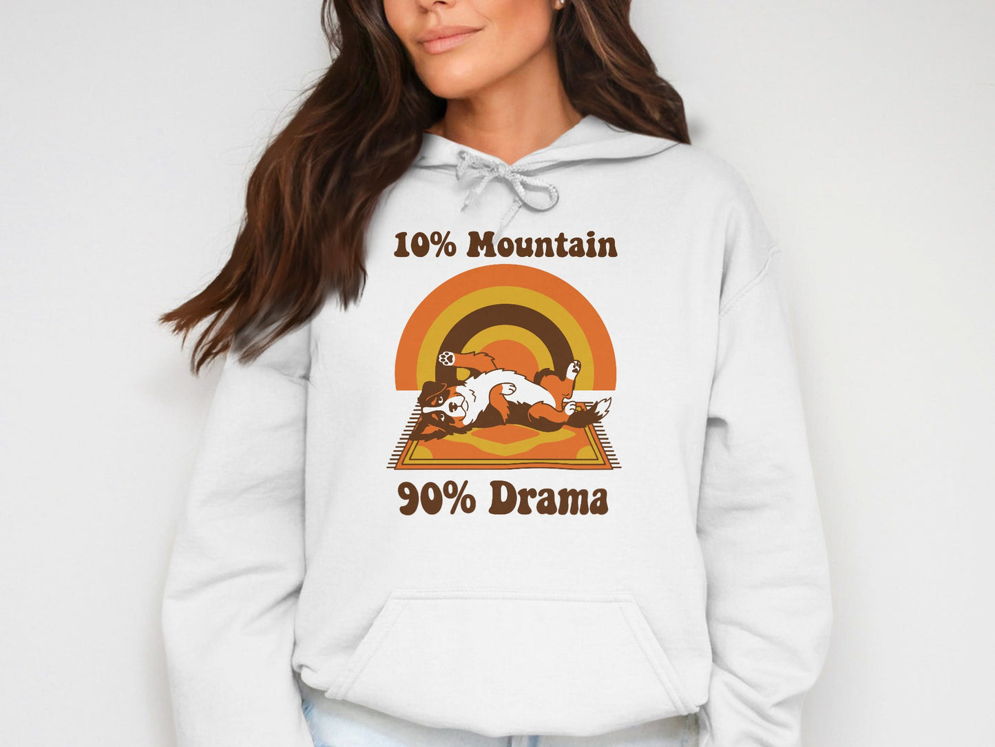 White hoodie with "10% Mountain 90% Drama" text and a dog on a rug graphic.