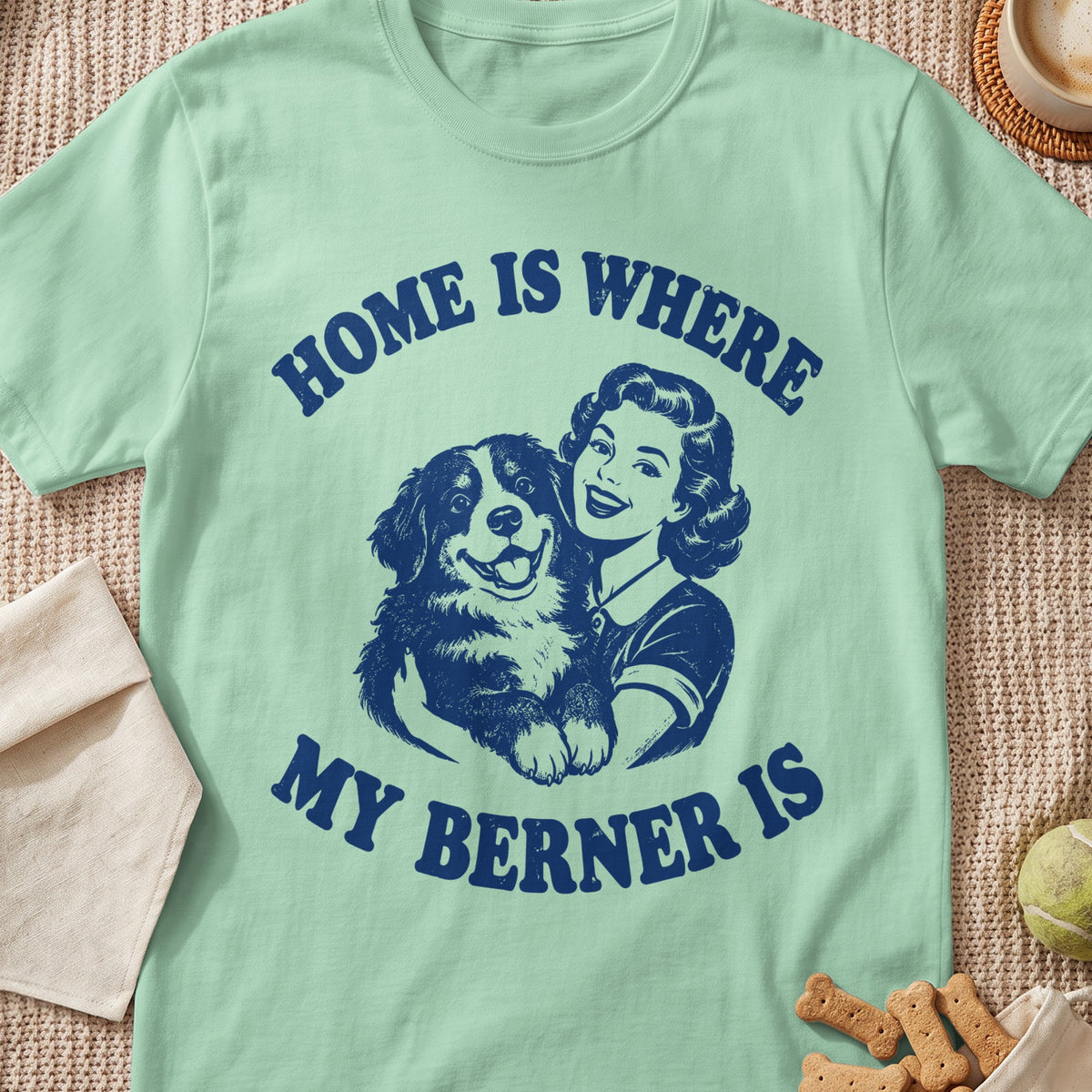 Mint green t-shirt with navy blue text and illustration of a woman holding a Bernese Mountain Dog.
