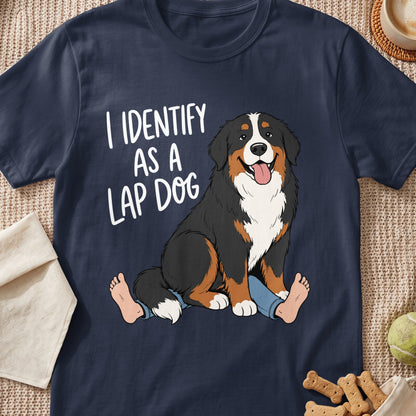Bernese Mountain Dog sitting on human legs with text "I IDENTIFY AS A LAP DOG".