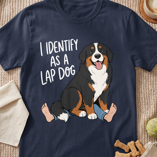 Bernese Mountain Dog sitting on human legs with text "I IDENTIFY AS A LAP DOG".