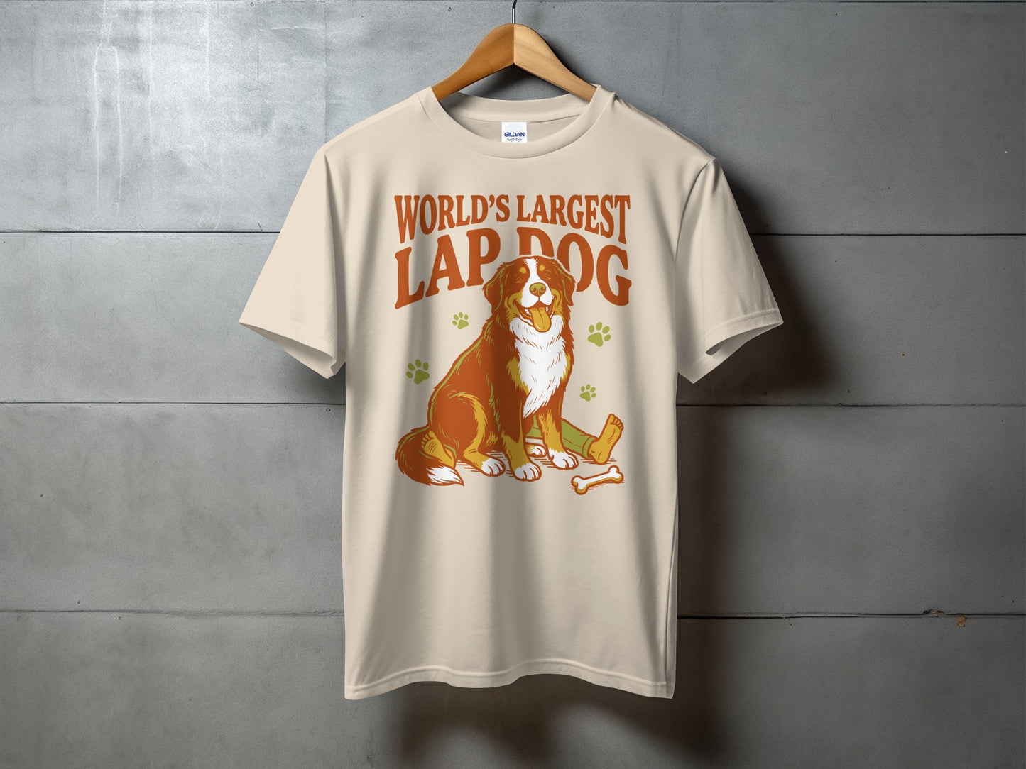 Bernese Mountain Dog graphic on a cream t-shirt with text "World's Largest Lap Dog".