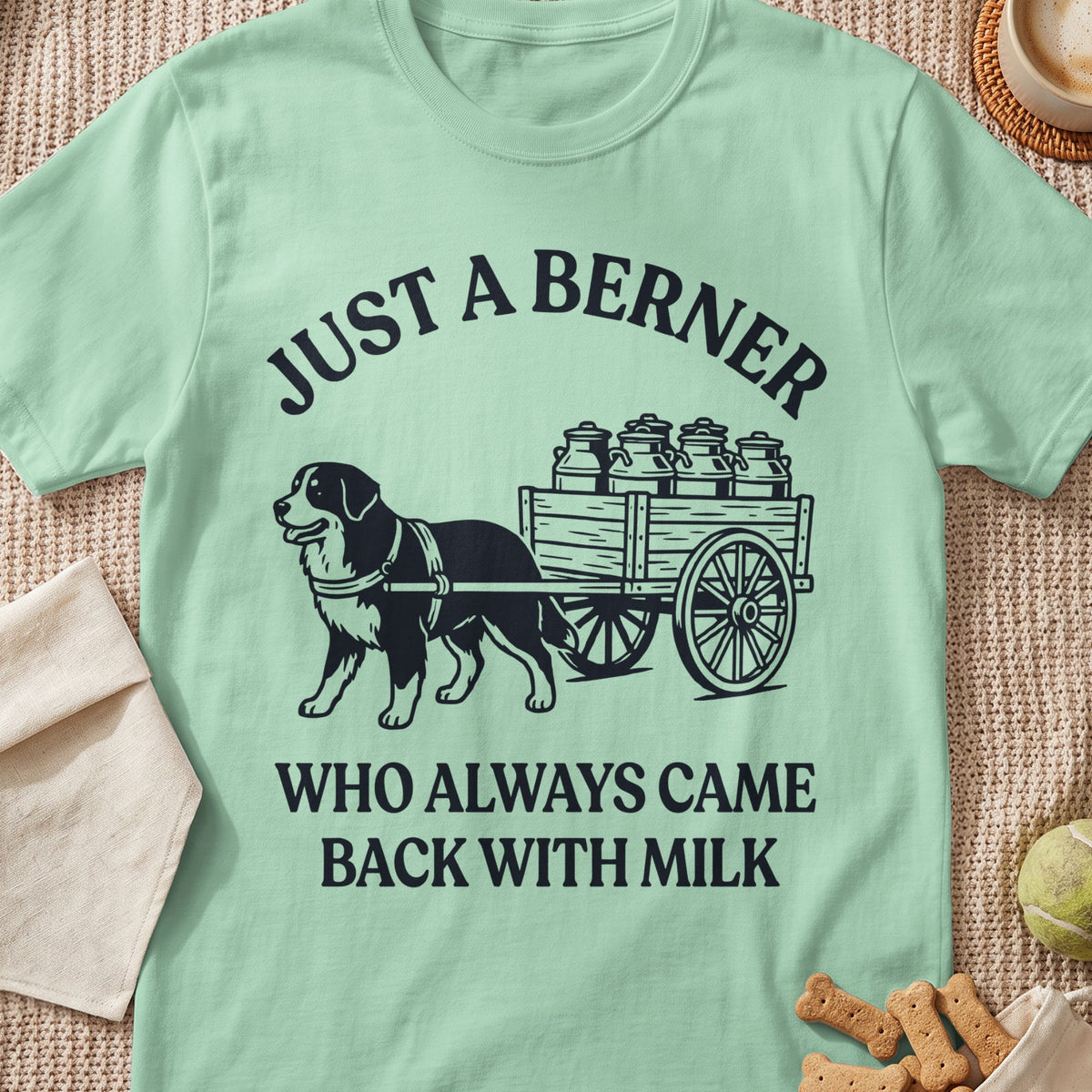 Light green t-shirt with black graphic of dog pulling cart of milk cans and text.