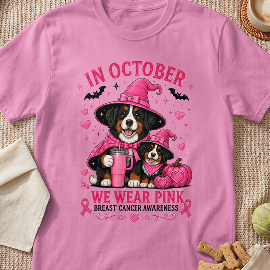 Two Bernese Mountain Dogs wear witch hats; "In October We Wear Pink" text.