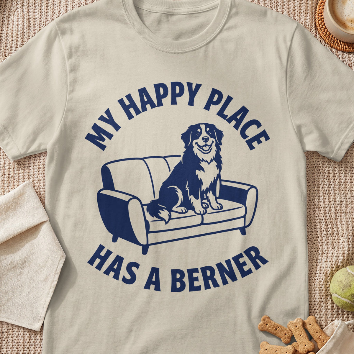 T-shirt with dark blue graphic of a dog on a couch and text "MY HAPPY PLACE HAS A BERNER".